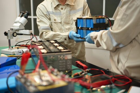 The skilled technician works on the lithium phosphate battery circuit board with his partner.