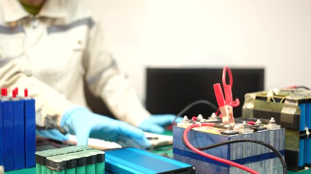 The skilled technician works on the lithium phosphate battery circuit board with his partner.