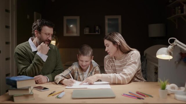 Father and mother explain something to child while doing homework at home. Parents help son with school homework. Parenting education guidance family concept