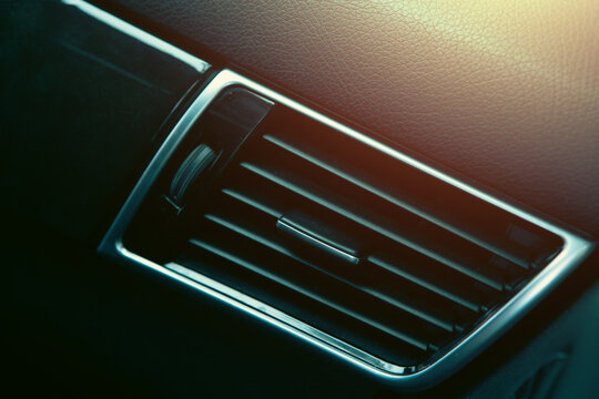 Modern car interior details, dashboard, steering wheel and air conditioning.