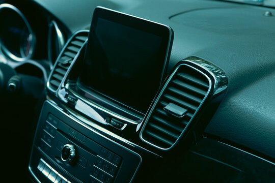 Modern car interior details, dashboard, steering wheel and air conditioning.