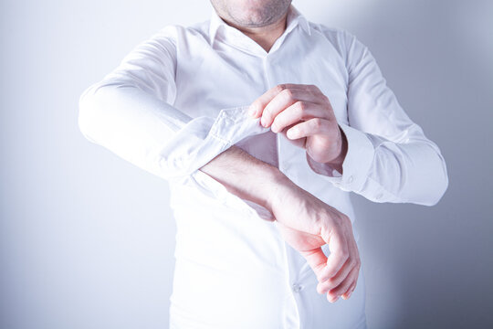 Man in a white shirt with a bandage on his wrist.