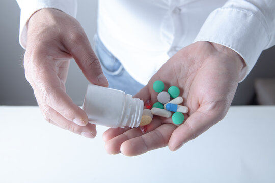 Man holding pills in his hand. Focus on foreground, soft bokeh.