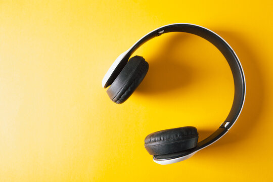Headphones on a yellow background. Top view with copy space.
