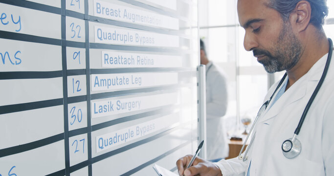 Doctor reviews a surgery schedule in a hospital, with copy space