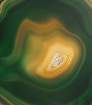 Green agate geode slice macro texture with amber crystal core