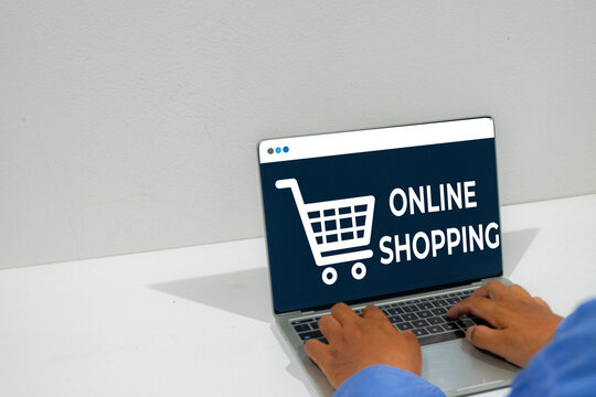 Man using a laptop computer for online shopping. Digital screen displaying a shopping cart icon. Concept of e-commerce, digital retail, internet purchasing, and modern consumerism.