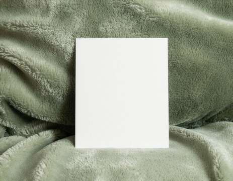 Blank white card mockup on a soft olive green cushion