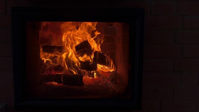 A crackling fire with bright orange flames in a stone fireplace. A warm stove, providing heat during the winter season. Saving electricity, fuel, and other resources. A crisis in the heating sector.