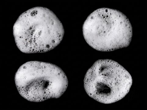 Set of four white soap foam blobs isolated on black background for hygiene product design