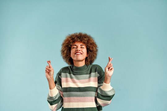 Smiling woman crossing fingers for luck.