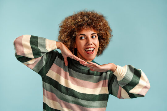 Smiling young woman posing in striped sweater.