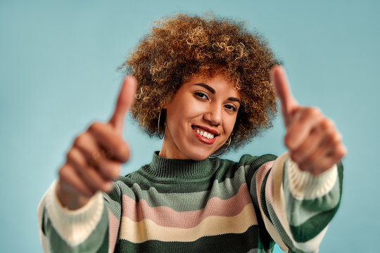 Smiling woman giving two thumbs up.