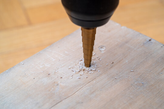 Drill bit penetrates wooden surface