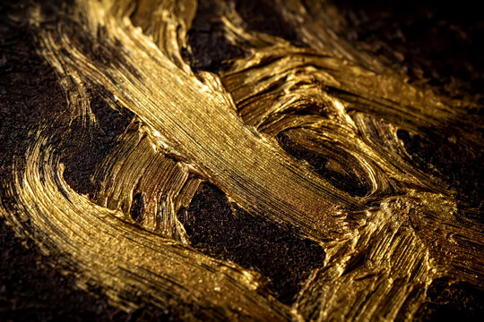 Gold paint brush strokes on dark textured background for luxury artistic backdrop