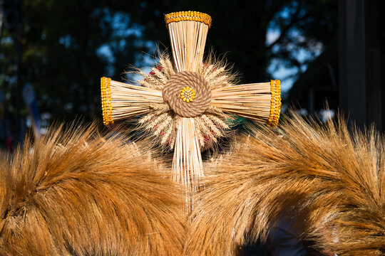 Close up of a woven cross made of wheat ears decorating a traditional harvest wreath during Polish thanksgiving harvest festival.