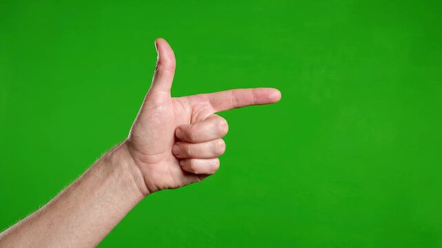 Confident male hand pointing finger gun gesture isolated against bright chroma key green screen background for video editing studio