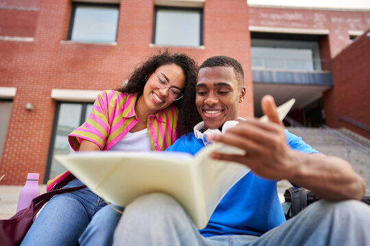 Diverse students studying together on campus steps
