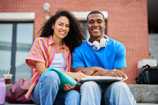 Diverse young college students sitting on campus steps