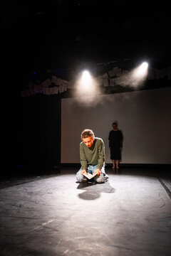 A striking solo scene lit by spotlights and drifting smoke