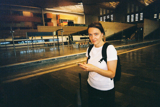 Woman Using Phone at Train Station
