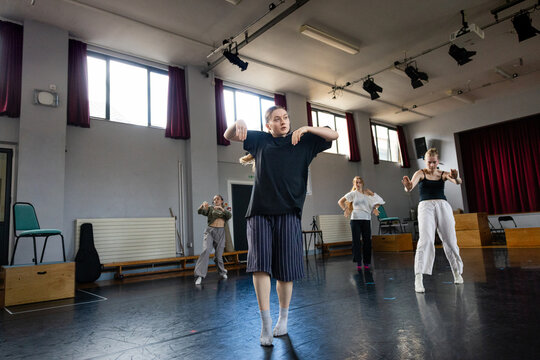 Group dance rehearsal with dynamic arm movement