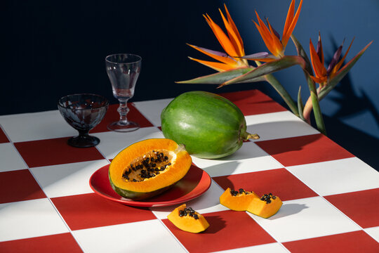 Retro still life photography of papaya fruit checkered surface