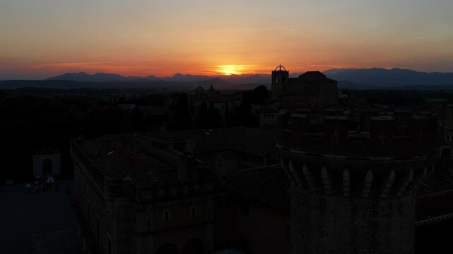 Sun setting behind castle towers silhouette Emporda Spain