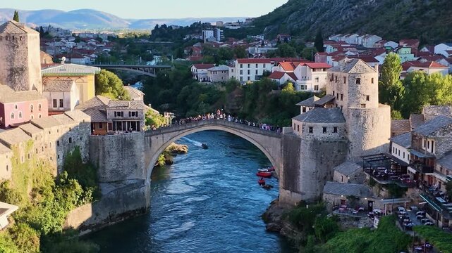 Scenic aerial drone footage of the historic Stari Most Old Bridge spanning the Neretva River in the city of Mostar, Bosnia and Herzegovina