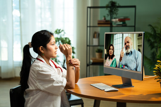 Young Indian Female Doctor Providing Online Consultation from Cozy Clinic