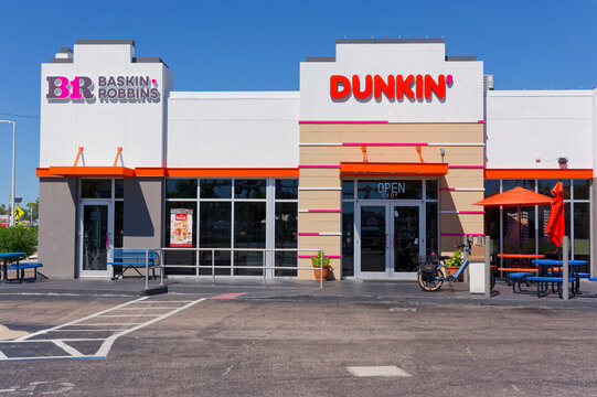 Bright Dunkin' and Baskin Robbins storefront with outdoor seating, signage and parking lot Editorial Use Only October 23, 2026 St. Pete Beach,FL USA under clear blue sky; urban fast‑casual coffee and 