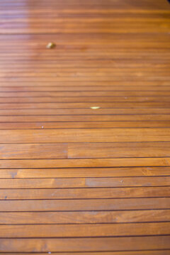Close up view of horizontal wooden deck planks with warm brown finish and shallow depth of field