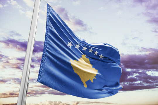 Kosovo flag waving in the wind against a cloudy sky