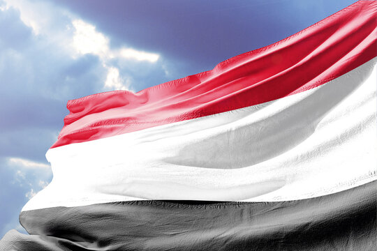 National Flag of Yemen Waving in the Wind against a Cloudy Sky