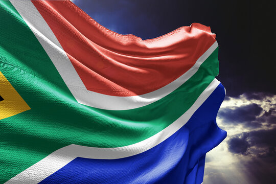 South African flag waving against a dramatic stormy sky
