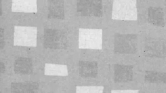 Grey fabric texture with repeating white square patterns in a grid layout
