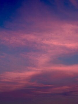 Dramatic vertical twilight sky with deep purple and magenta colored clouds