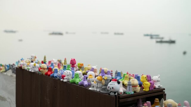 Cute colorful miniature figurines and souvenirs displayed on outdoor ledge