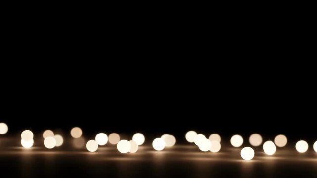 Warm white light orbs parading across a black backdrop