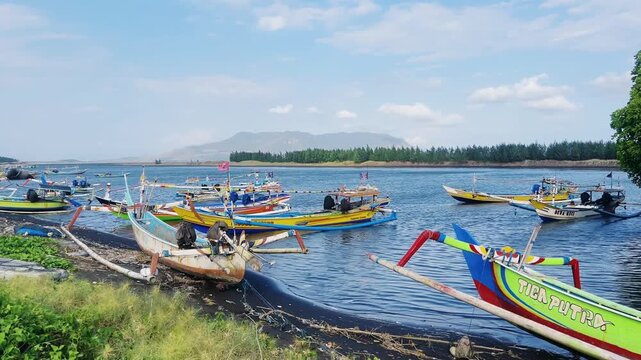 Indonesia, August 10, 2025: Fishing boats on the coast of the Indian Ocean. A group of fishing vessels. A colorful fishing fleet of traditional vessels on the island of Java, at the mouth of a river. 