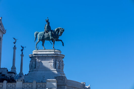 Equestrian statue of Victor Emmanuel II atop the Vittoriano monument against a clear blue sky in Rome, Italy