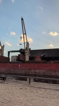 An excavator unloads raw material&mdash;sugar cane&mdash;from a cargo ship at the Redpath Sugar Refinery, a sugar storage, refining, and processing complex in Toronto, Ontario, Canada.