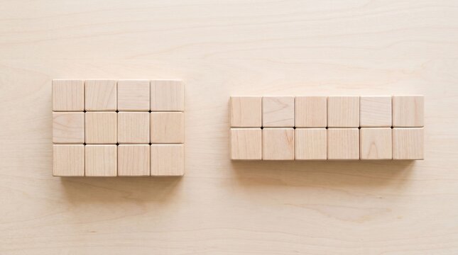 Top view of wooden unit cubes arranged in two multiplication rectangular arrays showing factor pairs of twelve on a tabletop
