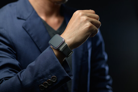 Business Professional Showing Watch on Wrist in Formal Suit with Dark Background