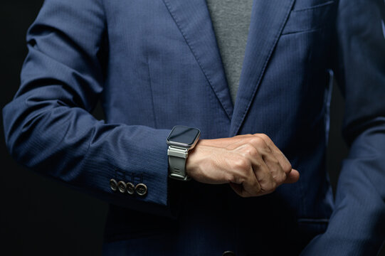 Businessman Checking Time on Wearable Smartwatch During Meeting or Conference
