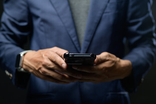 Businessman Holding Smartphone in Hands, Focus on Forearms and Phone