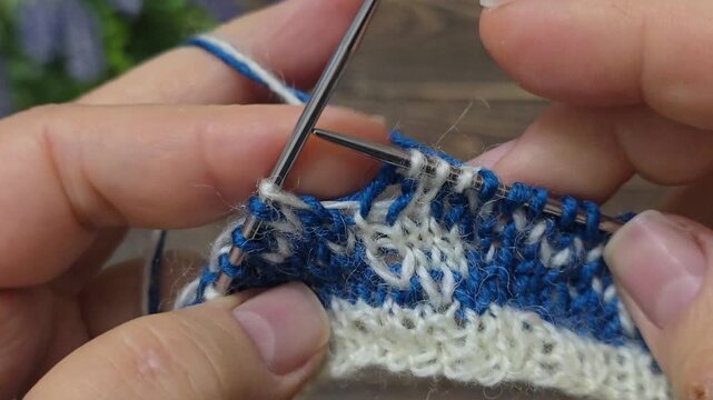 A knitted round yoke with a jacquard pattern in colored yarn on a wooden table. Knitting tutorials, backgrounds, and textures