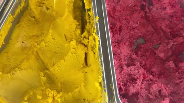 Various flavors of colorful Italian gelato ice cream spin in showcase at cafe. Assorted sweet frozen dessert assortment, multi colored refreshing summer food layout and creamy product rotation.