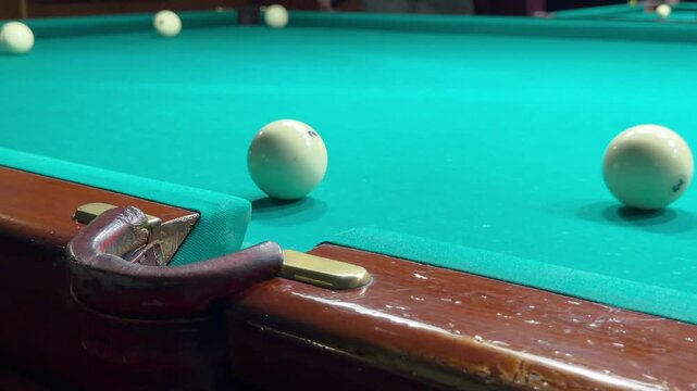 Player aims wooden cue stick to strike white Russian billiard ball but misses pocket. Indoor cue sport match process, failed shot attempt layout, green felt cloth table and active recreation hobby.