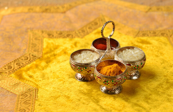 The traditional Kumkum  powder and rice grains in a tiny silver container.  Kumkum is used as a "Tilak" in India at auspicious occasion.
